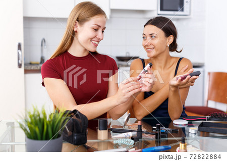 Women friends talking and applying make up 72822884