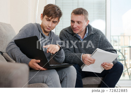 Guy with his father are resting and looking in notebook Guy with his father are resting and looking in notebook 72822885