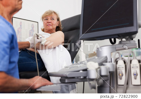 Man doctor examination a mature woman at abdomen 72822900