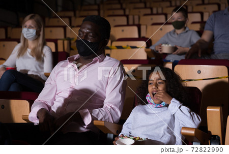 international family sitting at premiere in cinema 72822990