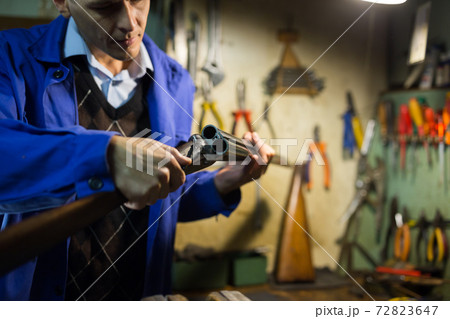 Break-action of horizontal double-barreled shotgun in hands of gunsmith Break-action of horizontal double-barreled shotgun in hands of gunsmith 72823647