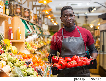 Salesman holding box with red peppers Salesman holding box with red peppers 72824145