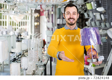 man in lighter shop choosing stylish and modern lamp for house interior man in lighter shop choosing stylish and modern lamp for house interior 72824148