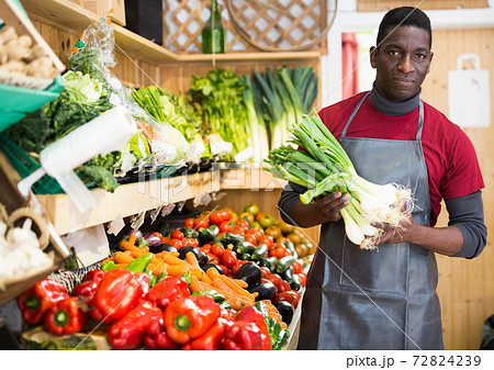 Salesman offering green onions 72824239