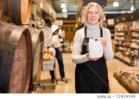 Saleswoman offering wine on tap 72824240