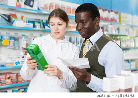 Experienced female pharmacist helping man client with prescription 72824242