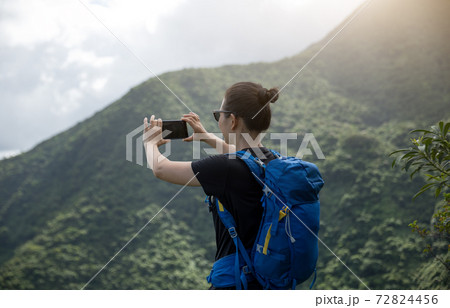 Woman hiker using smartphone on forest mountain top 72824456