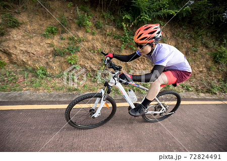 Woman riding bike down a slope with fast speedの写真素材 