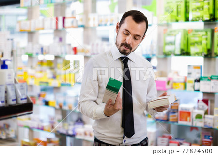 Smiling male customer looking for right medicine Smiling male customer looking for right medicine 72824500