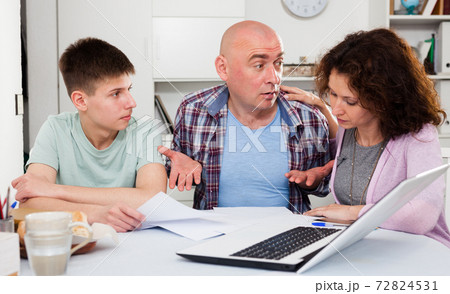 Chagrined family analyzing finances Chagrined family analyzing finances 72824531