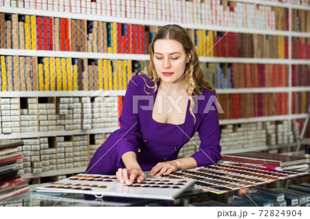 Woman choosing new dye for hair coloring Woman choosing new dye for hair coloring 72824904