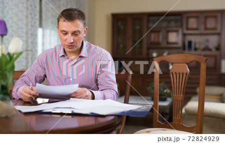 Man checking accountancy at home Man checking accountancy at home 72824929