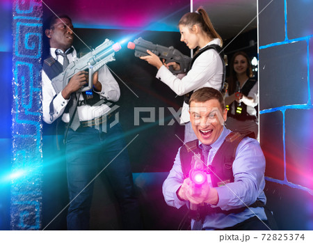 Men and women in business suits playing laser tag emotionally in Men and women in business suits playing laser tag emotionally in 72825374