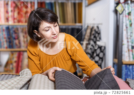 Woman choosing textiles in shop Woman choosing textiles in shop 72825661