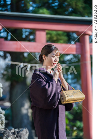寒さで手に息を吹きかける着物女性 72826265
