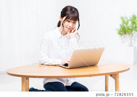 リビングでノートパソコンを使う女性 リビングでノートパソコンを使う女性 72826355