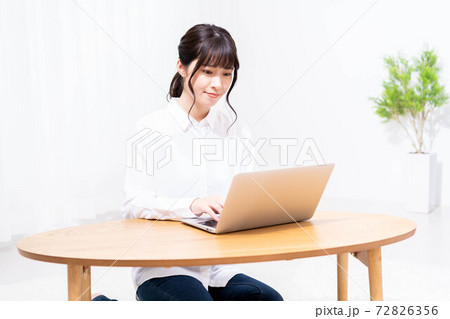 リビングでノートパソコンを使う女性 リビングでノートパソコンを使う女性 72826356