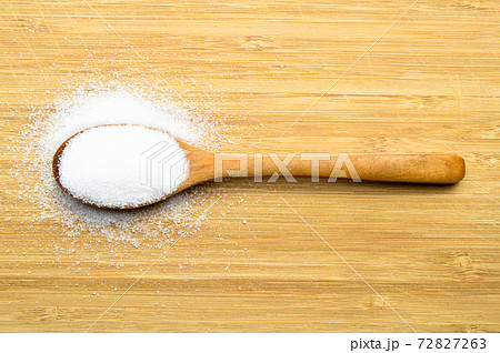 Granulated sugar in wooden spoon on bamboo cutting board, on bamboo cutting board Granulated sugar in wooden spoon on bamboo cutting board, on bamboo cutting board 72827263