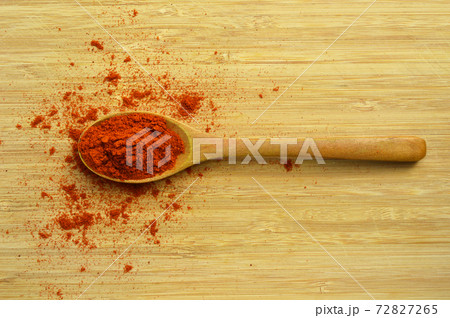 Dried red pepper in wooden spoon on bamboo cutting board Dried red pepper in wooden spoon on bamboo cutting board 72827265