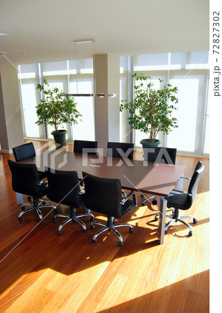 Empty meeting table and chairs in a modern conference room. Business meetings and ideas can be exchanged. Empty meeting table and chairs in a modern conference room. Business meetings and ideas can be exchanged. 72827302