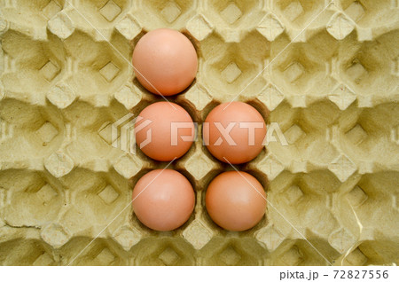 Fresh organic brown eggs in a carton package, protected paper yellow egg box Fresh organic brown eggs in a carton package, protected paper yellow egg box 72827556