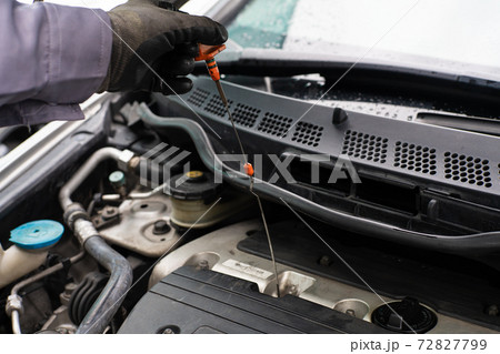 Mechanic man checking engine oil refill car maintenance Mechanic man checking engine oil refill car maintenance 72827799