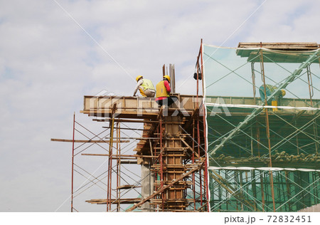 MALACCA, MALAYSIA -MARCH 14, 2020: Construction workers working at height at the construction site. They are supplied with harnesses and other safety equipment to prevent them from having an accident. MALACCA, MALAYSIA -MARCH 14, 2020: Construction workers working at height at the construction site. They are supplied with harnesses and other safety equipment to prevent them from having an accident. 72832451