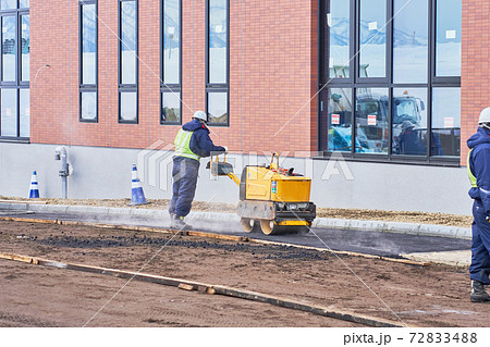 ハンドガイドローラーでアスファルトを締める作業 72833488