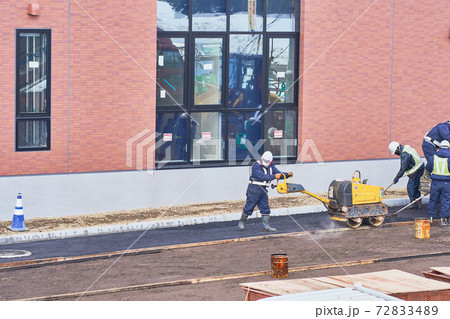 ハンドガイドローラーでアスファルトを締める作業 72833489