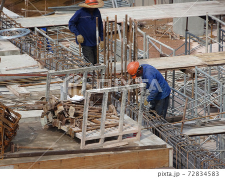 KUALA LUMPUR, MALAYSIA -JUNE 20, 2017: Construction workers fabricating steel reinforcement bar at the construction site. The reinforcement bar was tied together using tiny wire. KUALA LUMPUR, MALAYSIA -JUNE 20, 2017: Construction workers fabricating steel reinforcement bar at the construction site. The reinforcement bar was tied together using tiny wire. 72834583