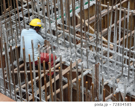 KUALA LUMPUR, MALAYSIA -JUNE 20, 2017: Construction workers fabricating steel reinforcement bar at the construction site. The reinforcement bar was tied together using tiny wire. 72834585