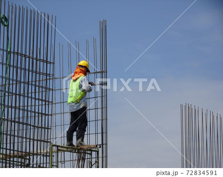KUALA LUMPUR, MALAYSIA -JUNE 20, 2017: Construction workers fabricating steel reinforcement bar at the construction site. The reinforcement bar was tied together using tiny wire. 72834591