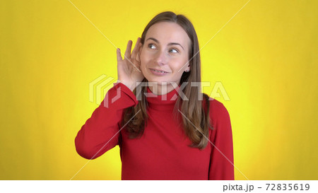 Fun woman isolated on yellow wall background studio. People sincere emotions lifestyle concept. Looking aside try to hear you with hand at ear overhears secrets Fun woman isolated on yellow wall background studio. People sincere emotions lifestyle concept. Looking aside try to hear you with hand at ear overhears secrets 72835619
