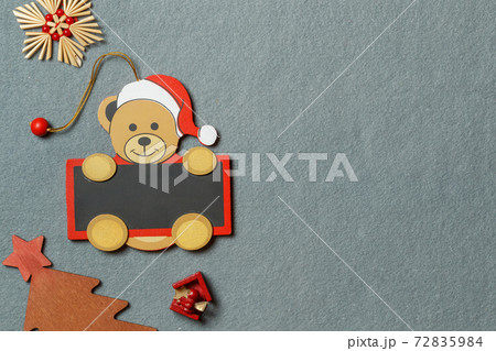 Christmas decorations made of wood and straw on a gray textile background. Horizontally with space Christmas decorations made of wood and straw on a gray textile background. Horizontally with space 72835984