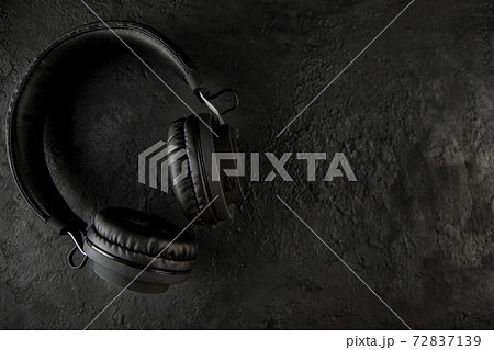 Headphones on a black stone background Headphones on a black stone background 72837139