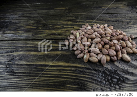 Raw peanuts on a rough wooden background. Raw peanuts on a rough wooden background. 72837500