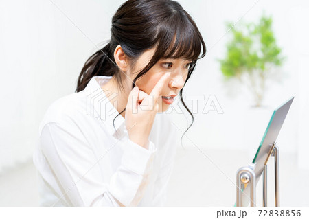 コンタクトレンズをつけようとする女性 72838856