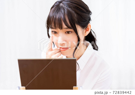 コンタクトレンズをつけようとする女性 72839442