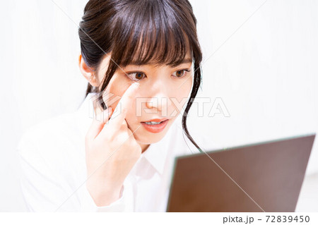 コンタクトレンズをつけようとする女性 72839450
