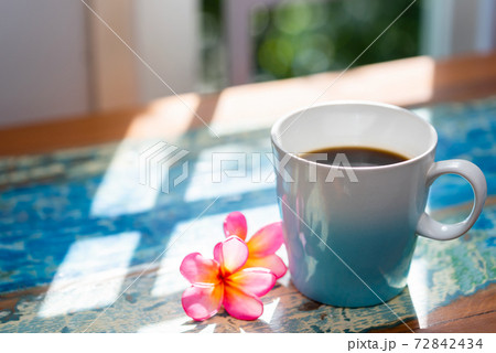 夏の日の窓辺に置かれたコーヒーカップとカラフルな南国の花 72842434
