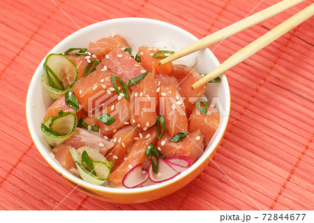 Hawaiian poke with salmon, sesame seeds and boiled rice on bamboo napkin. Hawaiian poke with salmon, sesame seeds and boiled rice on bamboo napkin. 72844677