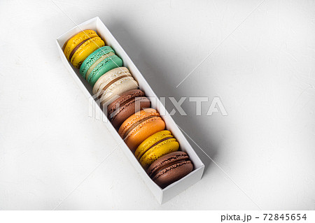 Round multicolored macaroon cakes on a light background. Home delivery. Festive concept. Quarantine. Round multicolored macaroon cakes on a light background. Home delivery. Festive concept. Quarantine. 72845654