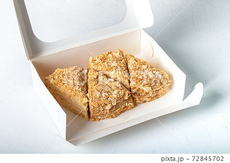 Festive puff pastry cake with custard. On a light background. Sprinkled with crumbs. Birthday, holidays, sweets. Festive puff pastry cake with custard. On a light background. Sprinkled with crumbs. Birthday, holidays, sweets. 72845702