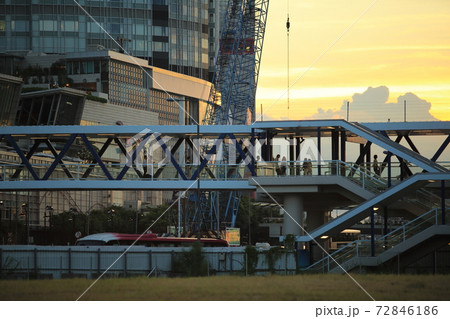 people pass through the busy footbridge to the ferry pier behind the IFC international finance center in Central, Hong Kong under the sunset 72846186