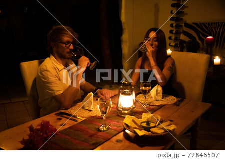 Couple drink wine at table by candlelight Couple drink wine at table by candlelight 72846507