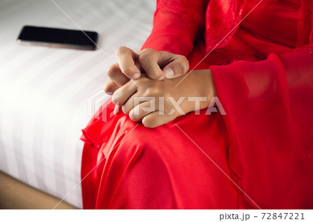 The sad pensive woman in the red nightgown at night. 72847221