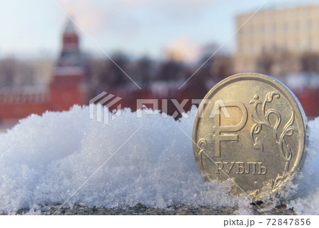 A coin worth one Russian ruble against the backdrop of the Moscow Kremlin. 72847856