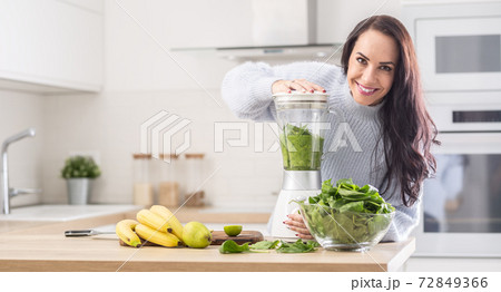 Green blend of smoothie made by a woman on healthy diet at home 72849366