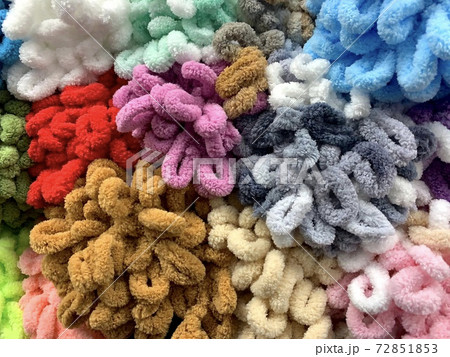 Multicolored skeins of plush yarn for hand knitting with ready made loops. Background from a set of fleece curly.  72851853