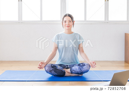 リビングでオンラインヨガする若い女性 リビングでオンラインヨガする若い女性 72852708